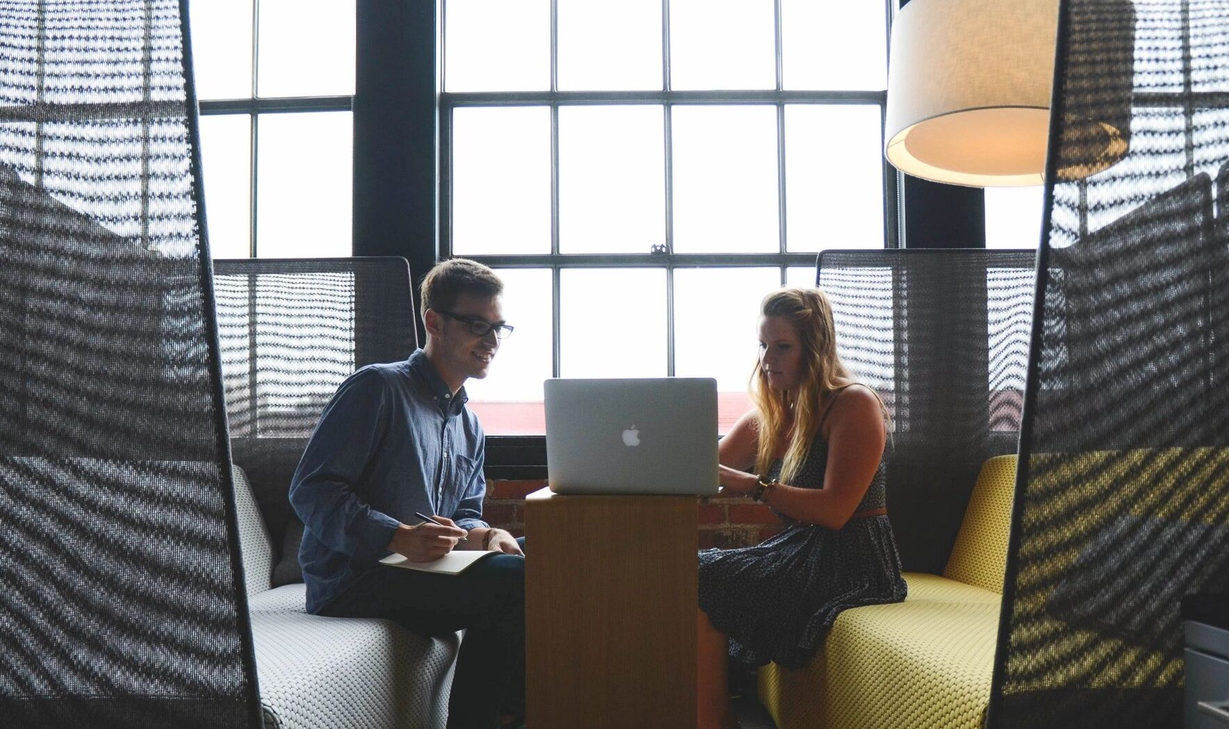Photo of two business consultants looking at a laptop, waiting for you to contact us.